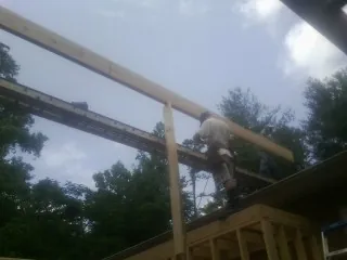 Carpenter setting a ridge beam over a new addition frame — Ice Dam Removal by Roofing Brothers in French Gulch
