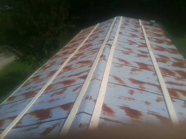 Rusted metal roof panels with new wood purlins before replacement — Storm Damage Roof Repair in French Gulch by Roofing Brothers