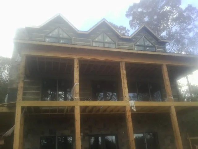 Dormers and porch framing on a large log home under construction — Roof Coating work by our crew in French Gulch
