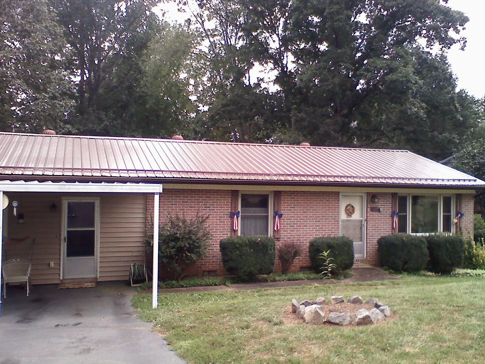 Bronze metal roof and carport on a brick ranch home — Roof Repair work by our crew in French Gulch