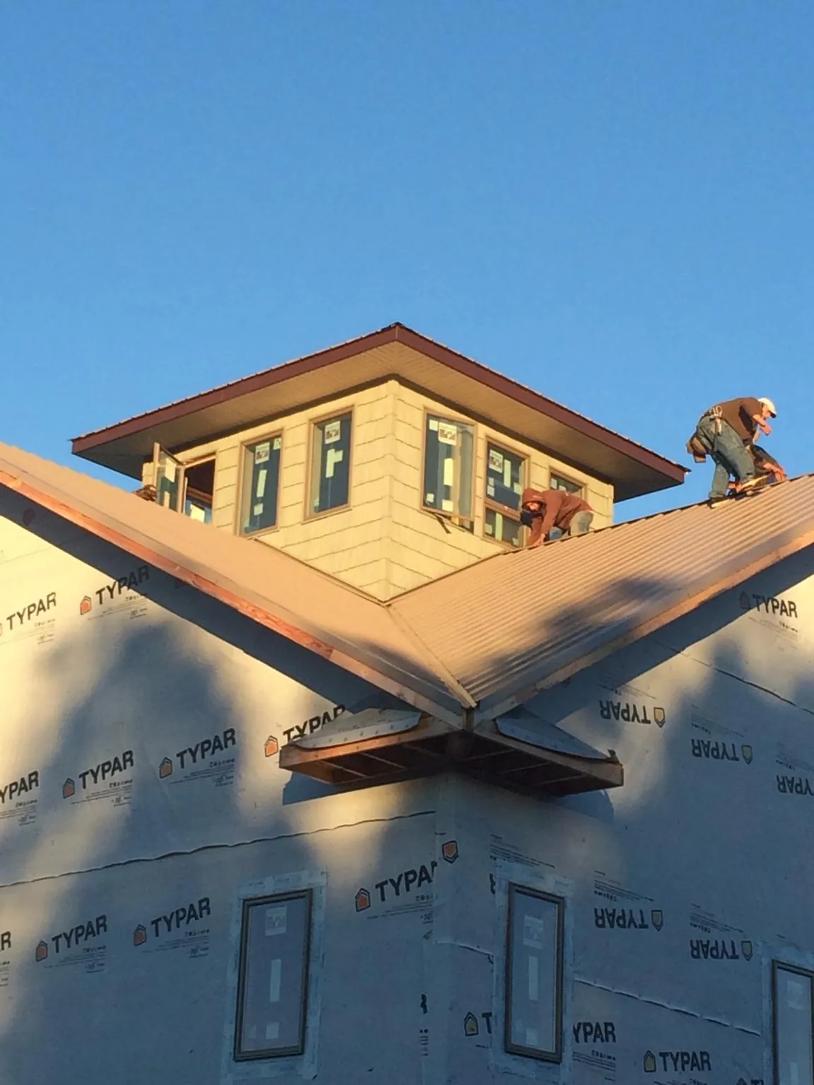 Roofers working around a rooftop cupola on a new metal roof at sunset — Roof Waterproofing in French Gulch by Roofing Brothers
